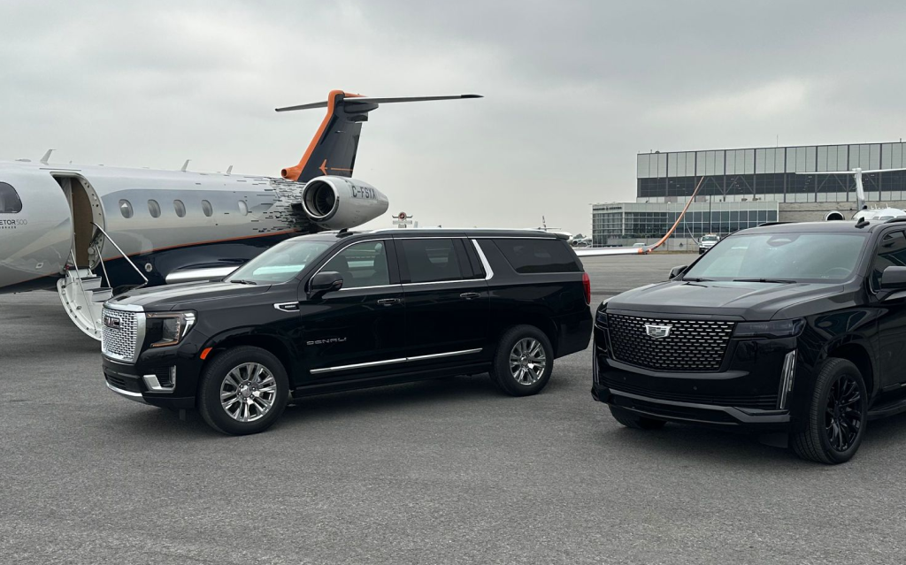 Black VIP Lane SUVs beside a private jet at the airport